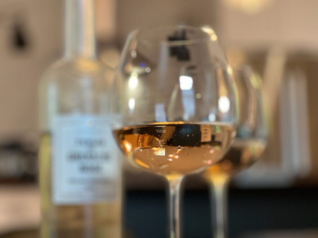 Closeup of rose wine in two glasses with the bottle blurred in the background.