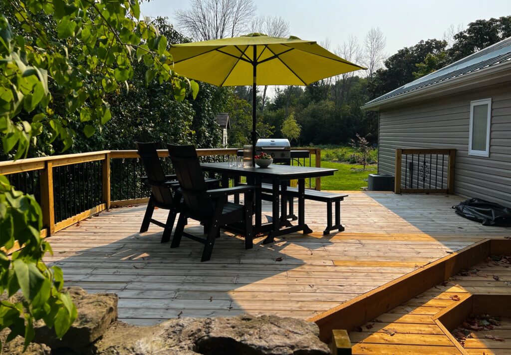 Photo of the kitchen deck with patio furniture and umbrella at SquirrelHaus PEC