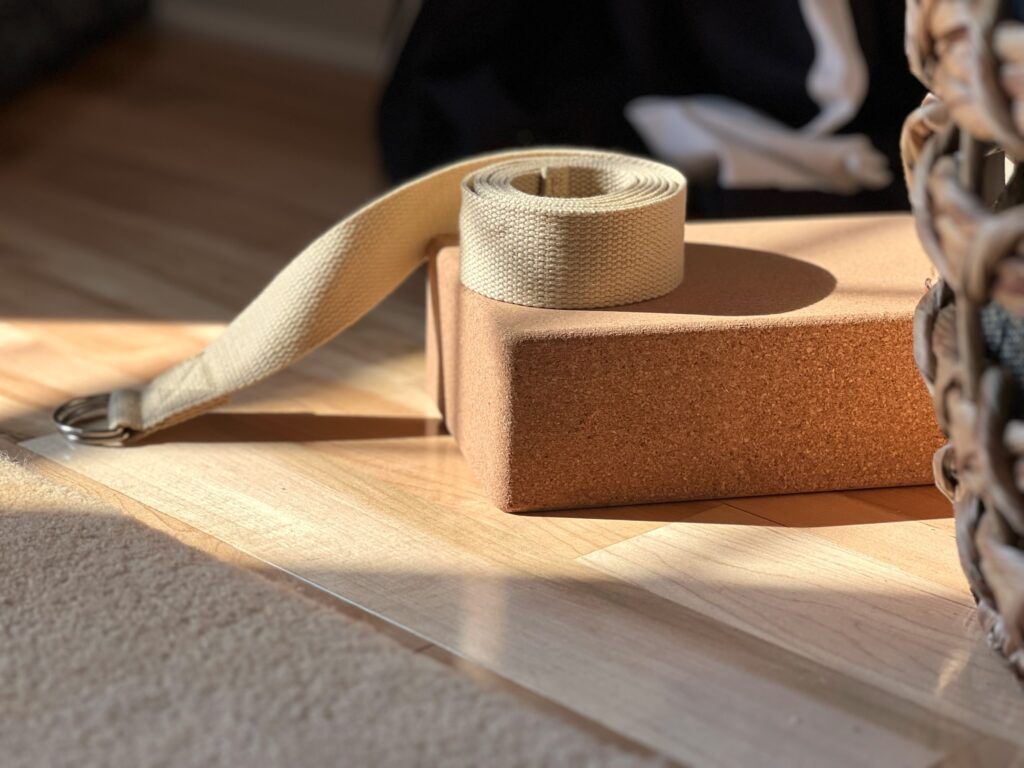 Photo of a cork yoga brick and hemp strap on the sunny wood floors at SquirrelHaus PEC
