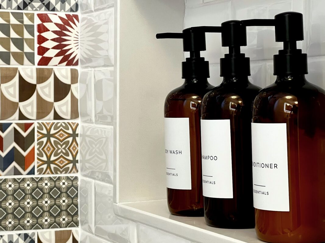 Photo of three bottles of bath products in a tiled shower niche at SquirrelHaus PEC