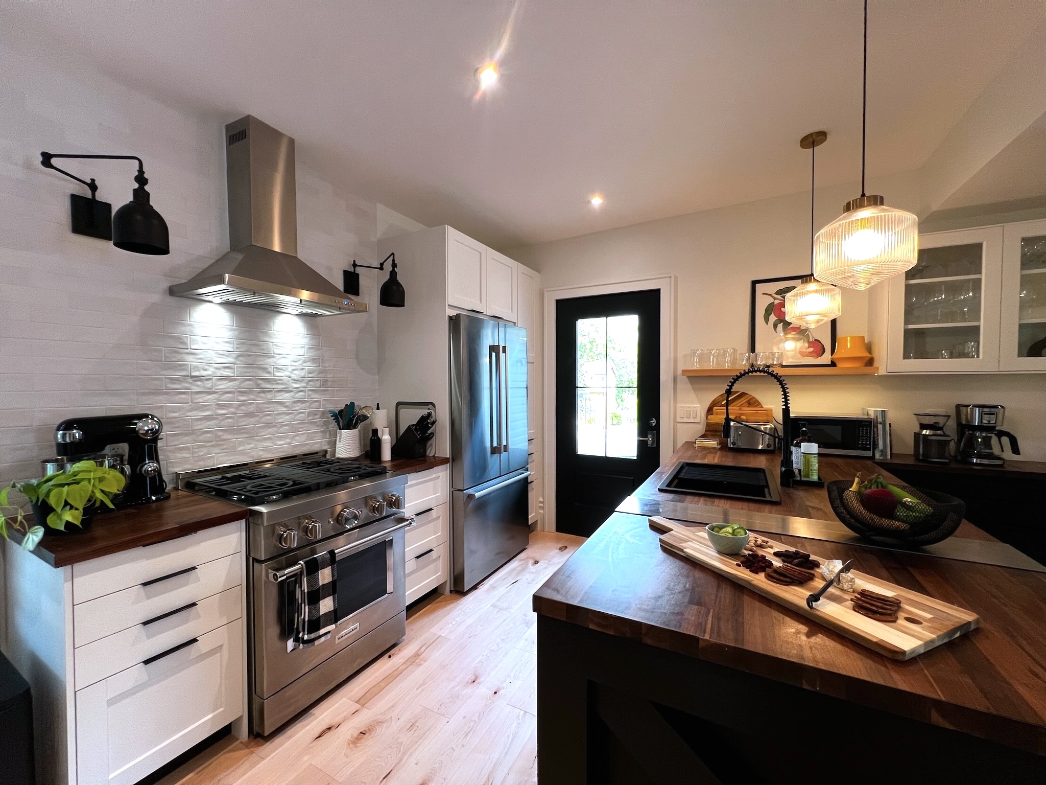 SquirrelHaus PEC kitchen with commercial-styled appliances, ample prep space, natural light, and a glass door to the deck.